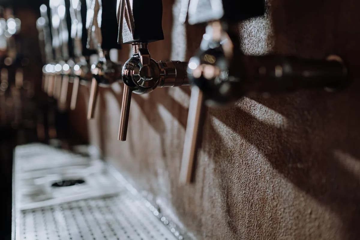 A row of chrome craft-beer tap handles at a Logan Square brewery taproom