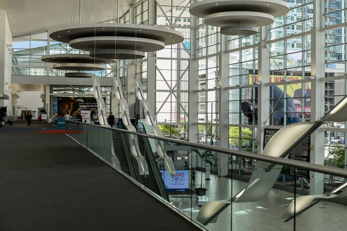A spacious modern convention center interior with escalators and a glass facade — large-event venue transportation