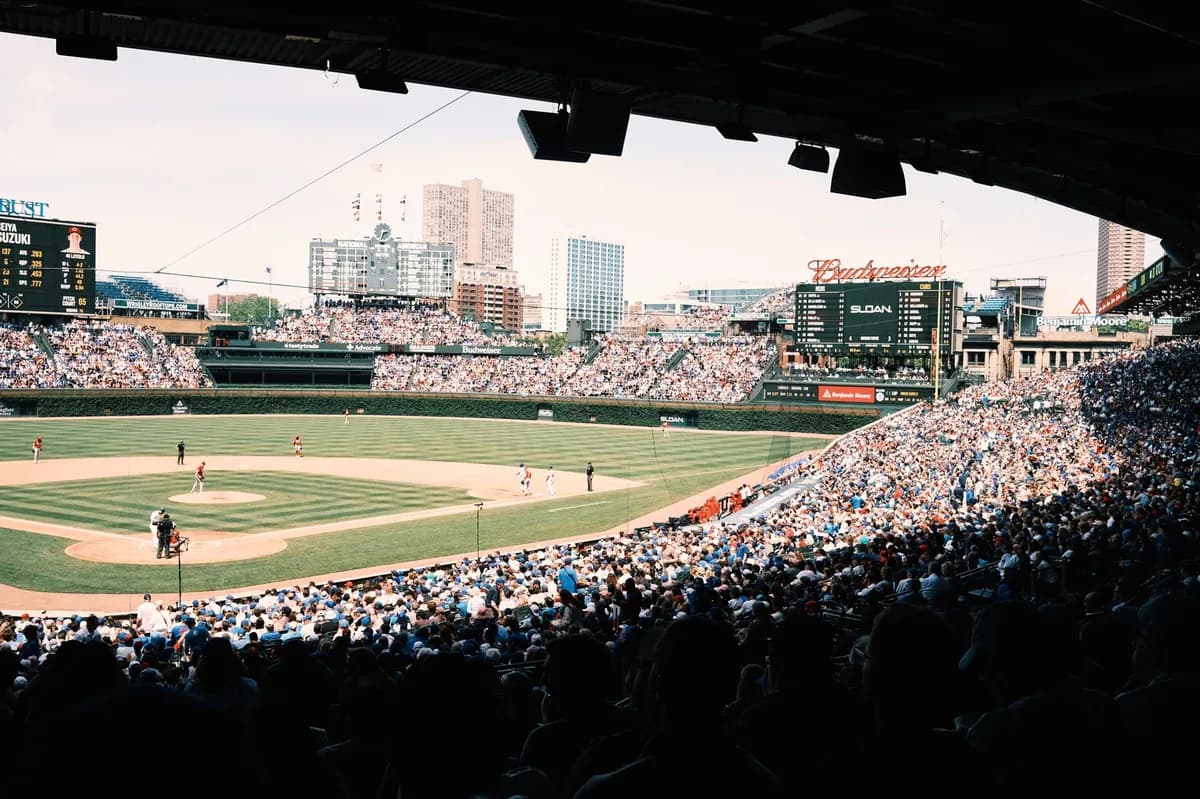 A packed ballpark on a sunny game day, filled with fans watching baseball